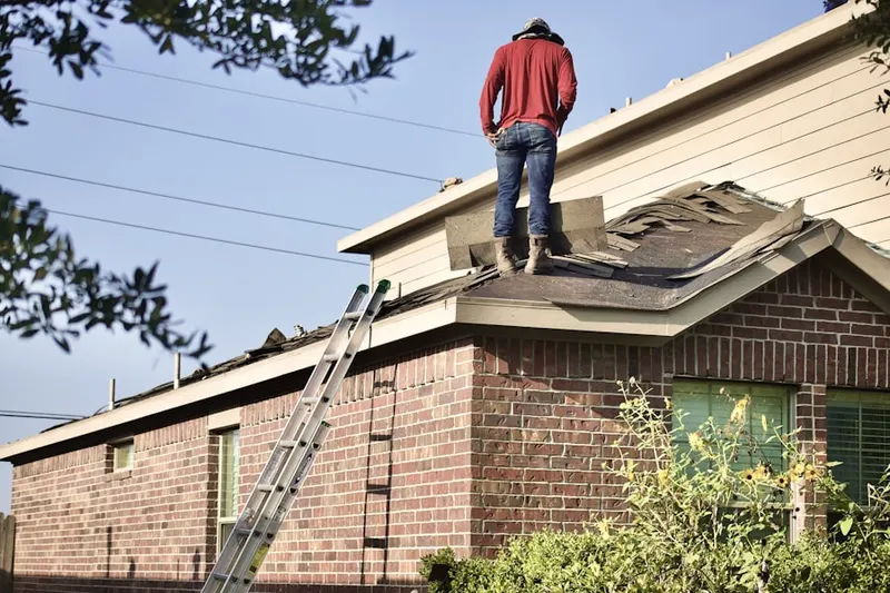 Professional roofer working on a residential roof in Gimghoul